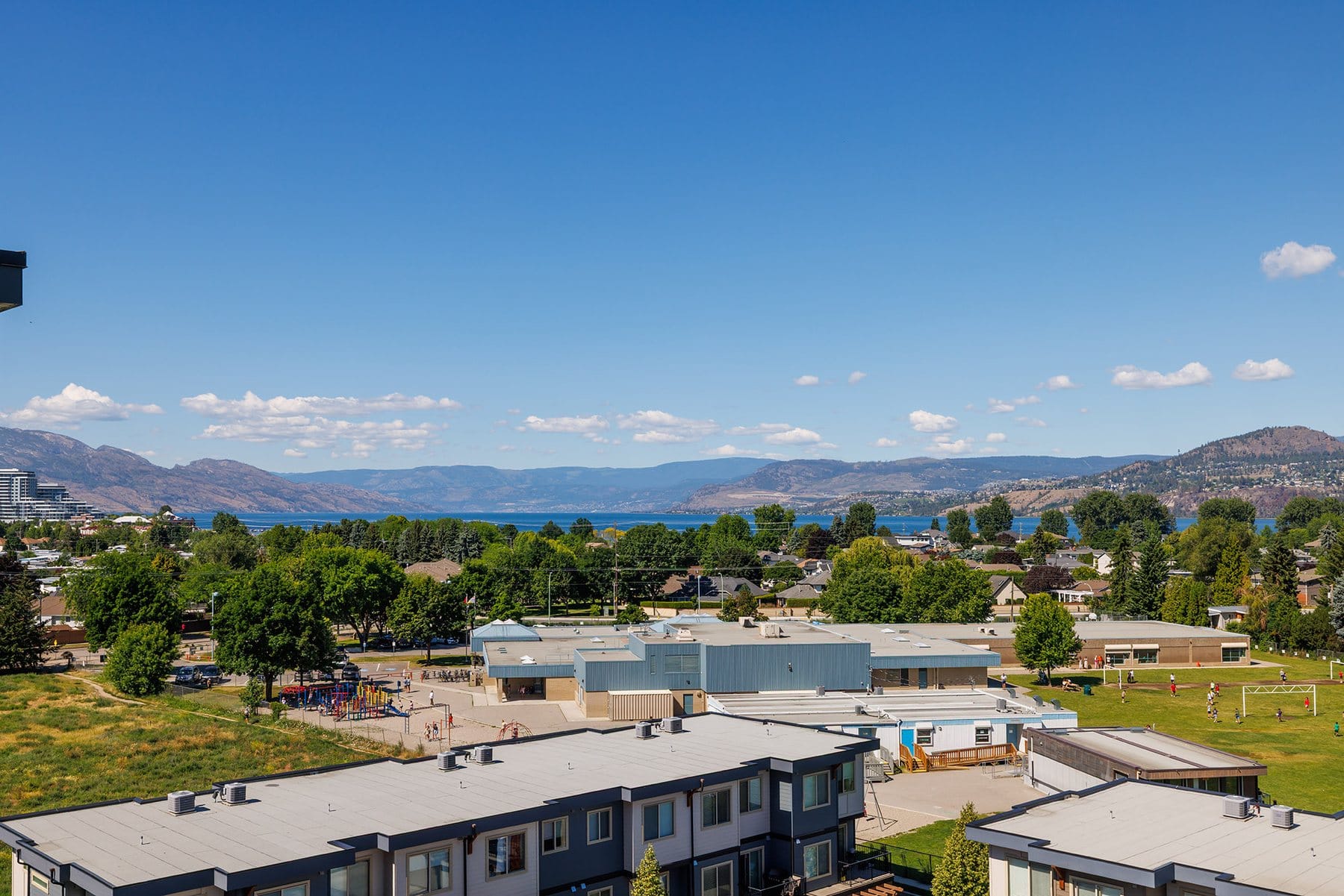 View from the Green Square penthouse over the Lower Mission school field and trees to Okanagan Lake