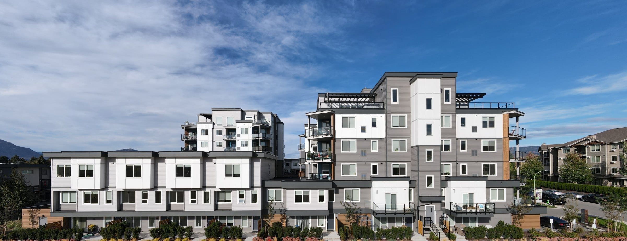 The two Vert buildings from the park: the townhome row in front and the two towers behind it
